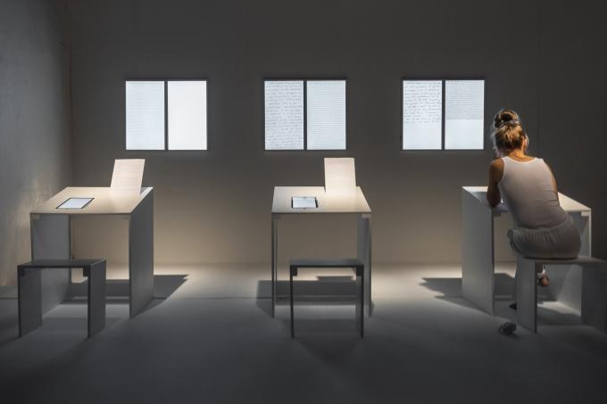 Artwork Karolina Żyniewicz "Signs of the Times" with a person siting at a table in front of it